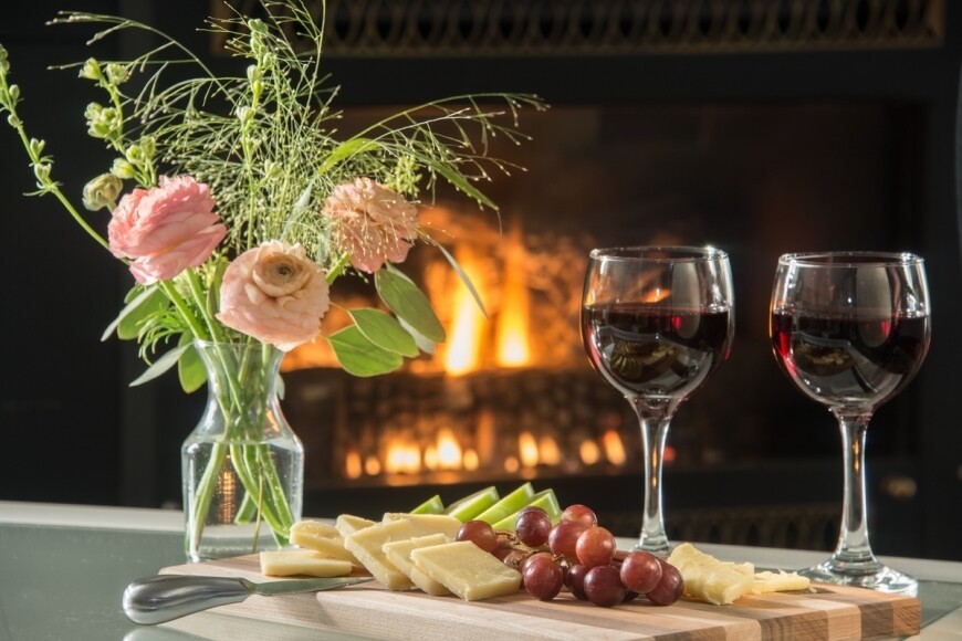 red wine and charcuterie board by fireplace