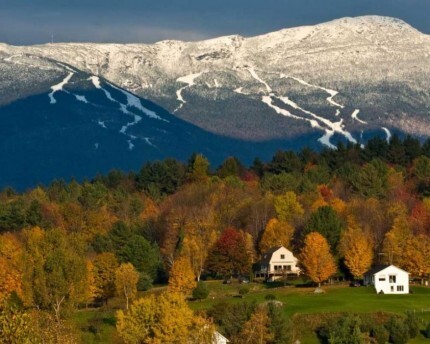 fall foliage in vermont with snowy mount mansfield in background