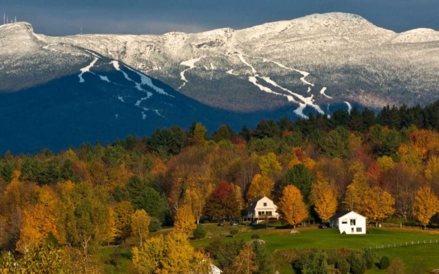 fall foliage in vermont with snowy mount mansfield in background